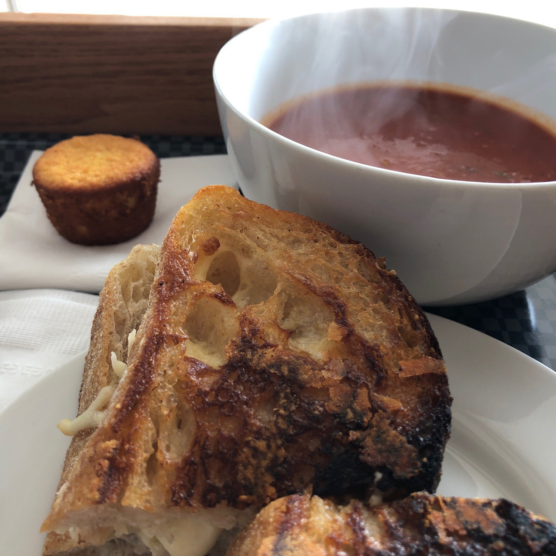 Grilled cheese and tomato soup in bowl with small muffin.