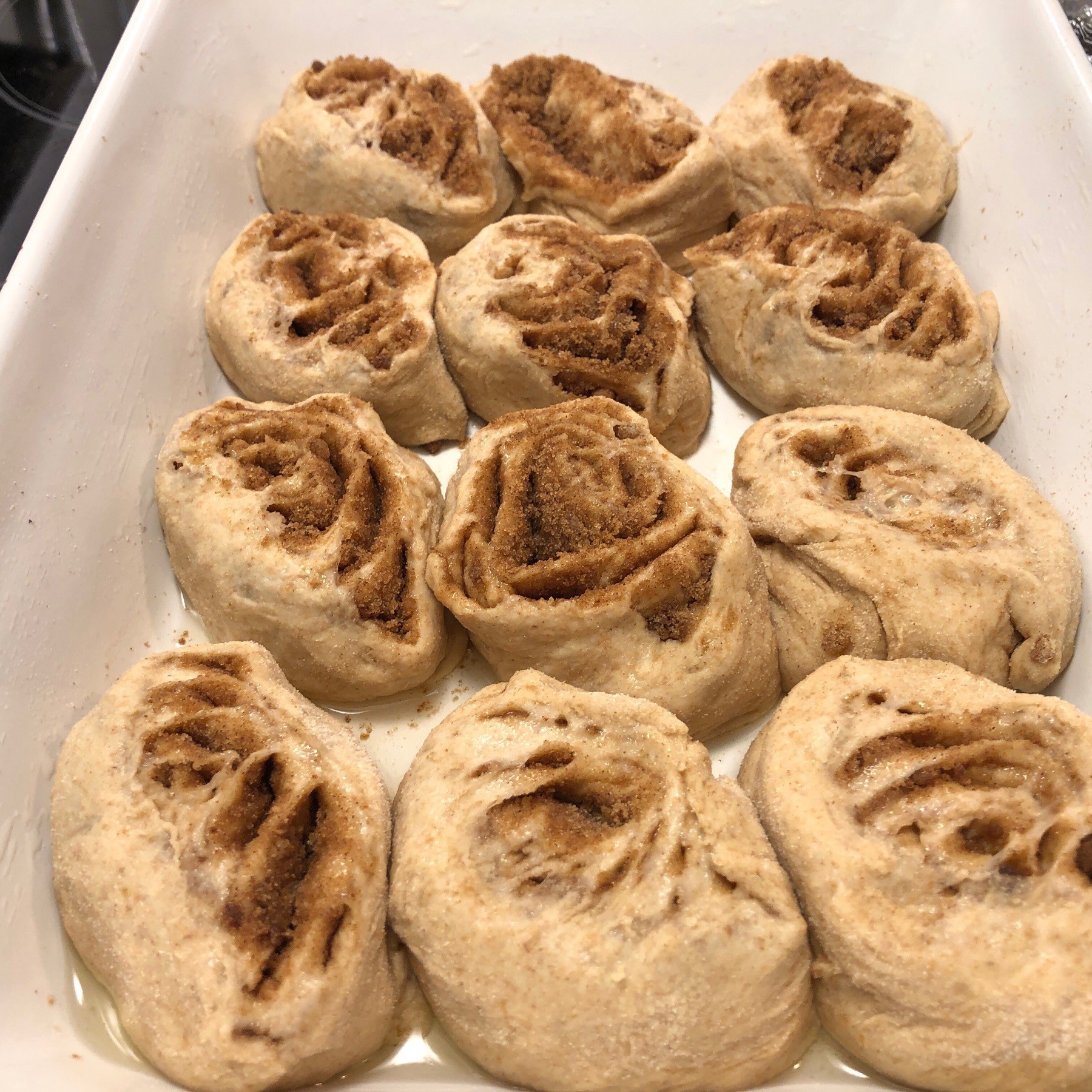 Cinnamon buns rising in a pan.