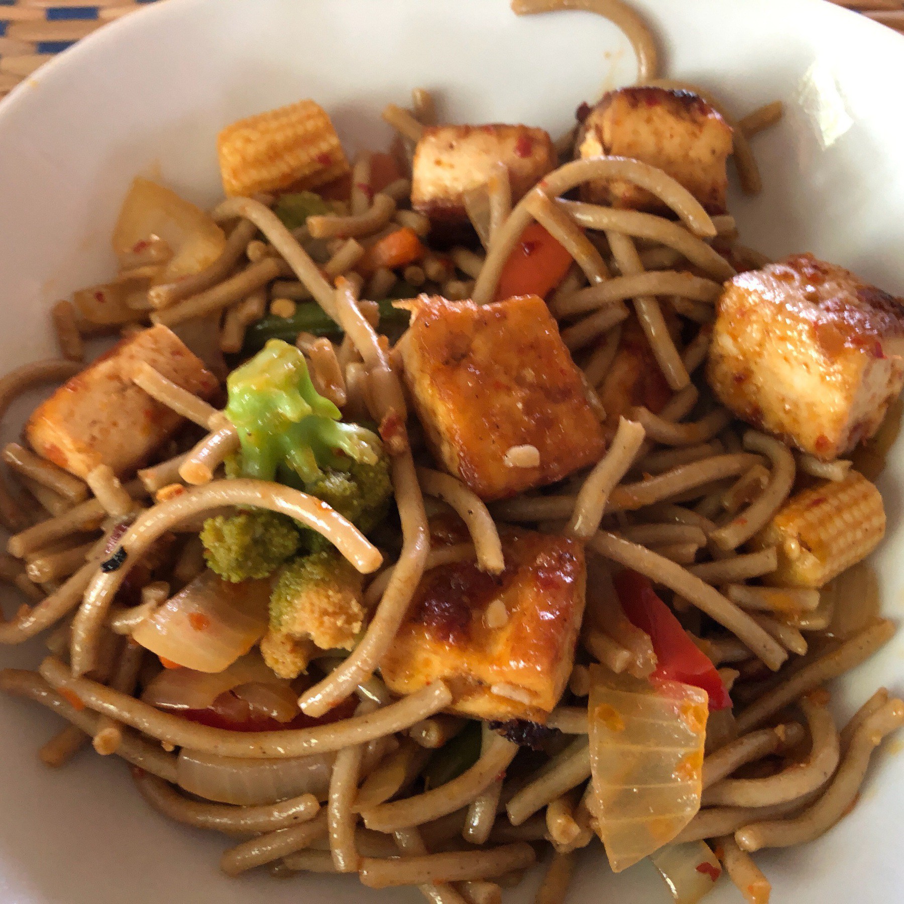 Sobs noodles, veggies, and tofu in a bowl.