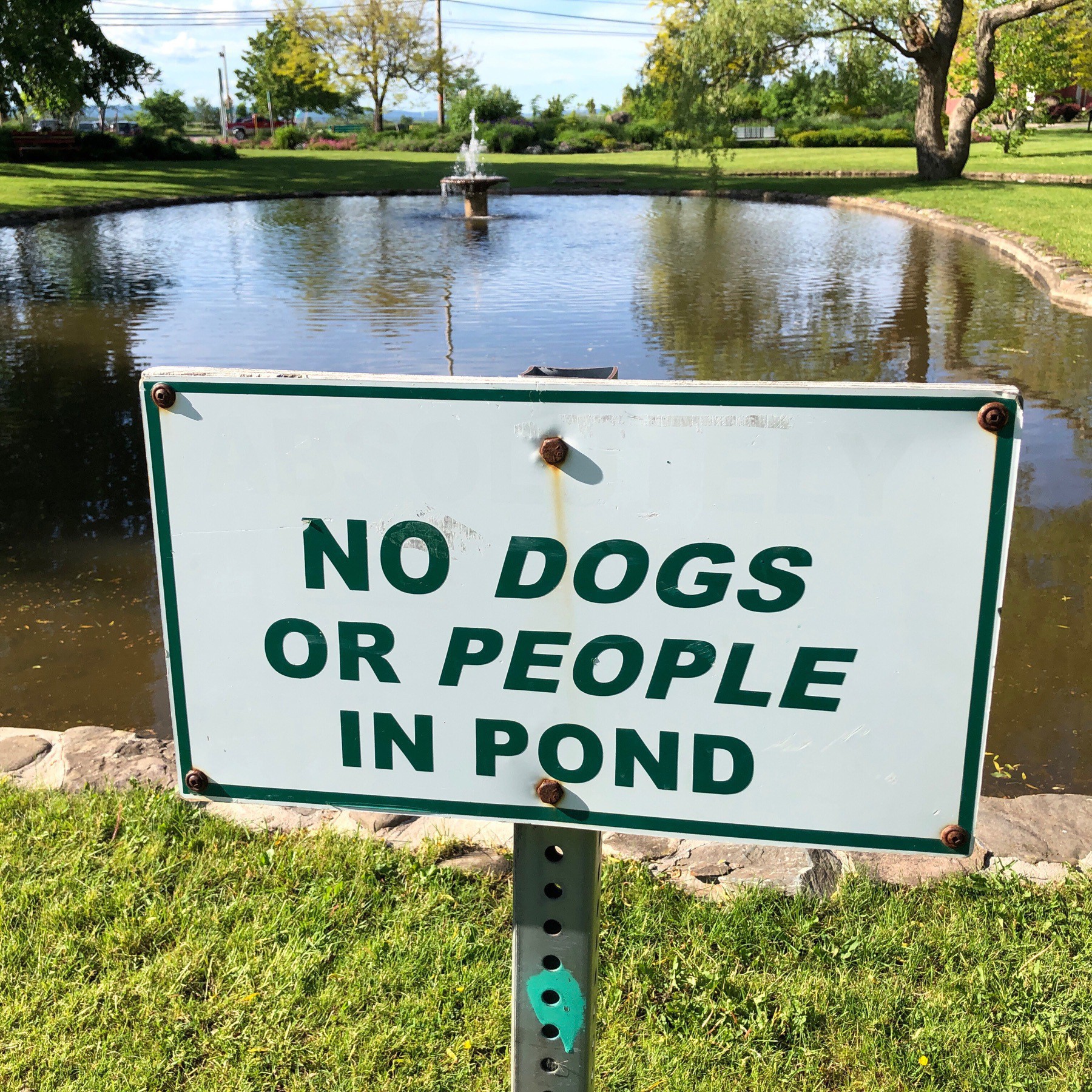 Sign beside pond.