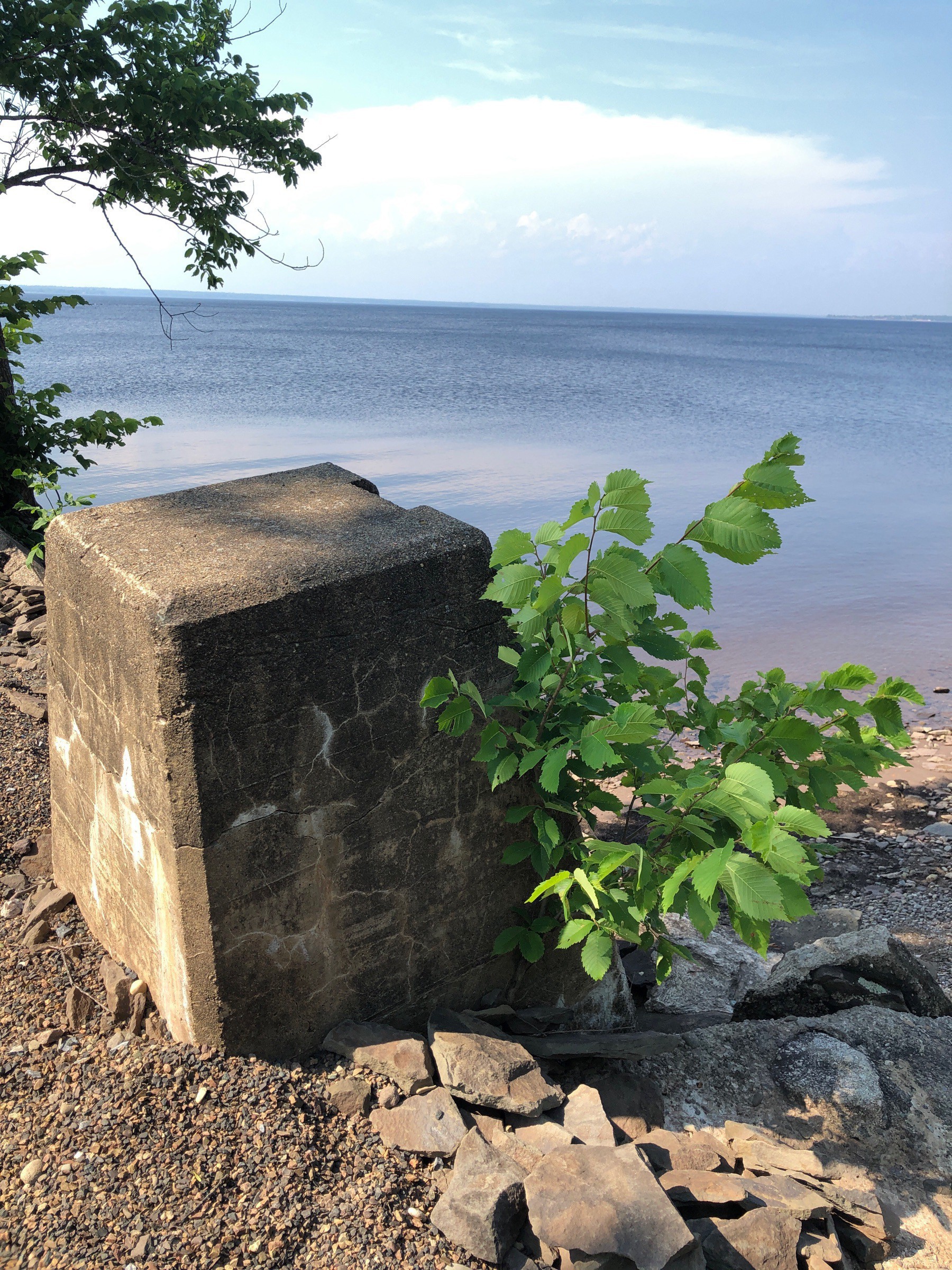 Concrete post beside lake.