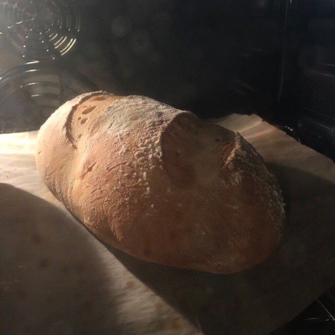 Loaf of bread baking in oven.